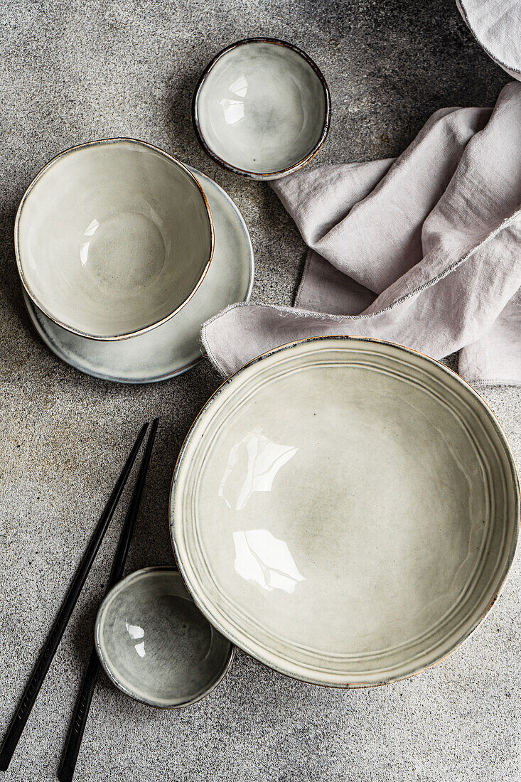 Top view grey ceramic tableware on the same color concrete background
