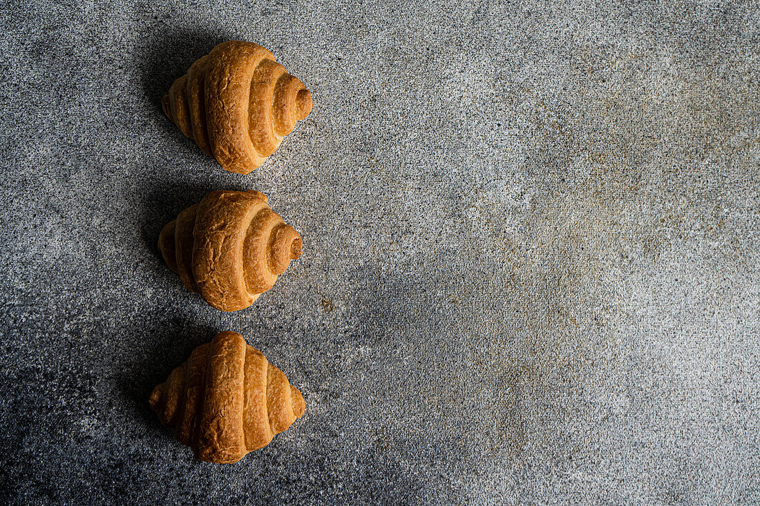 Top view of fresh baked croissants on the concrete background