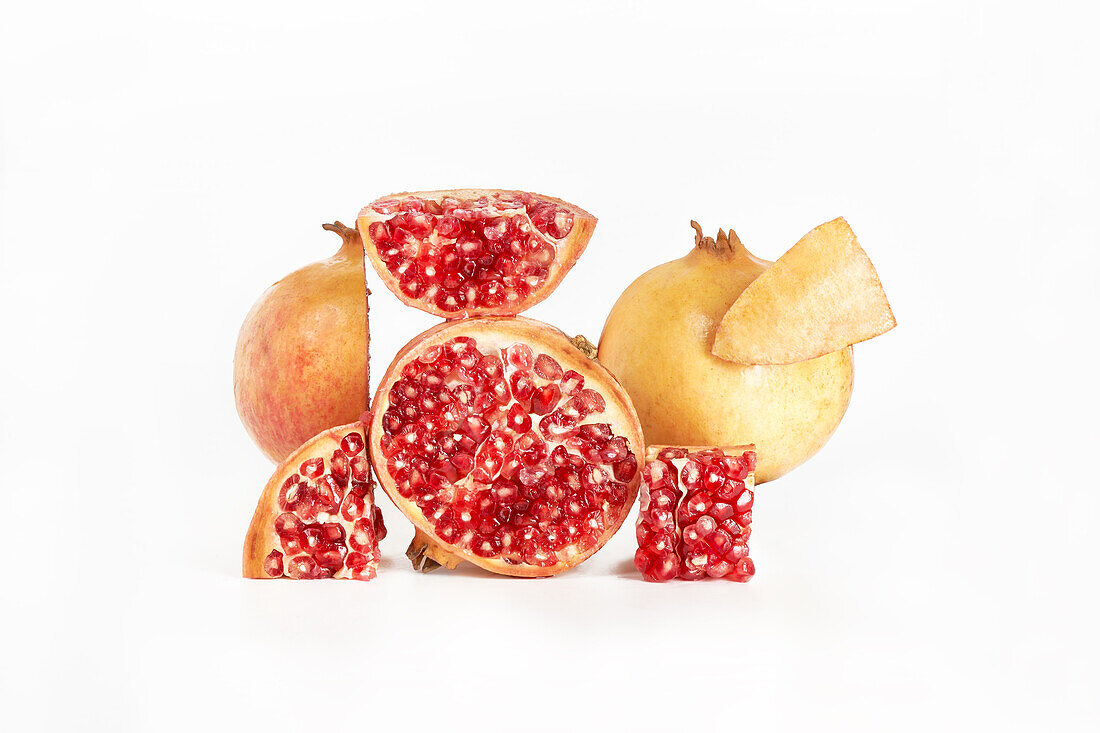 Deconstructed scene with beautifully arranged fresh healthy pomegranate with a white background