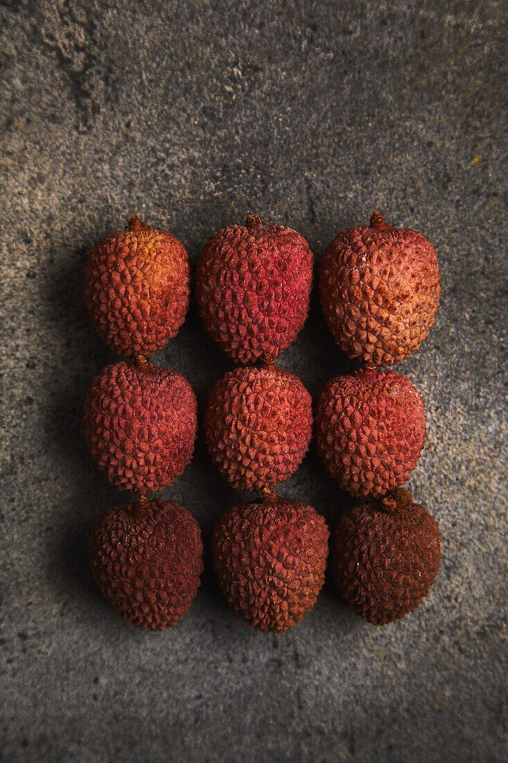 Top view of delicious fresh and ripe lychee fruits on smooth surface with brown background