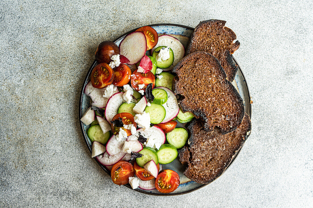 From above vegetable salad in Greek style with feta cheese on concrete background