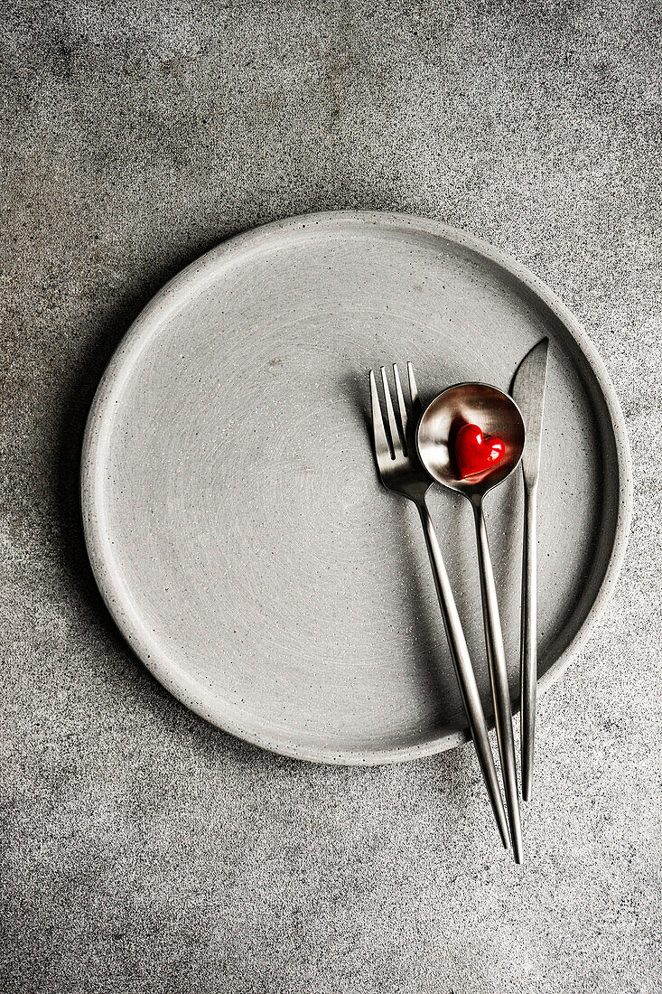 Valentine's Day sinner set decorated with red glass heart on concrete table