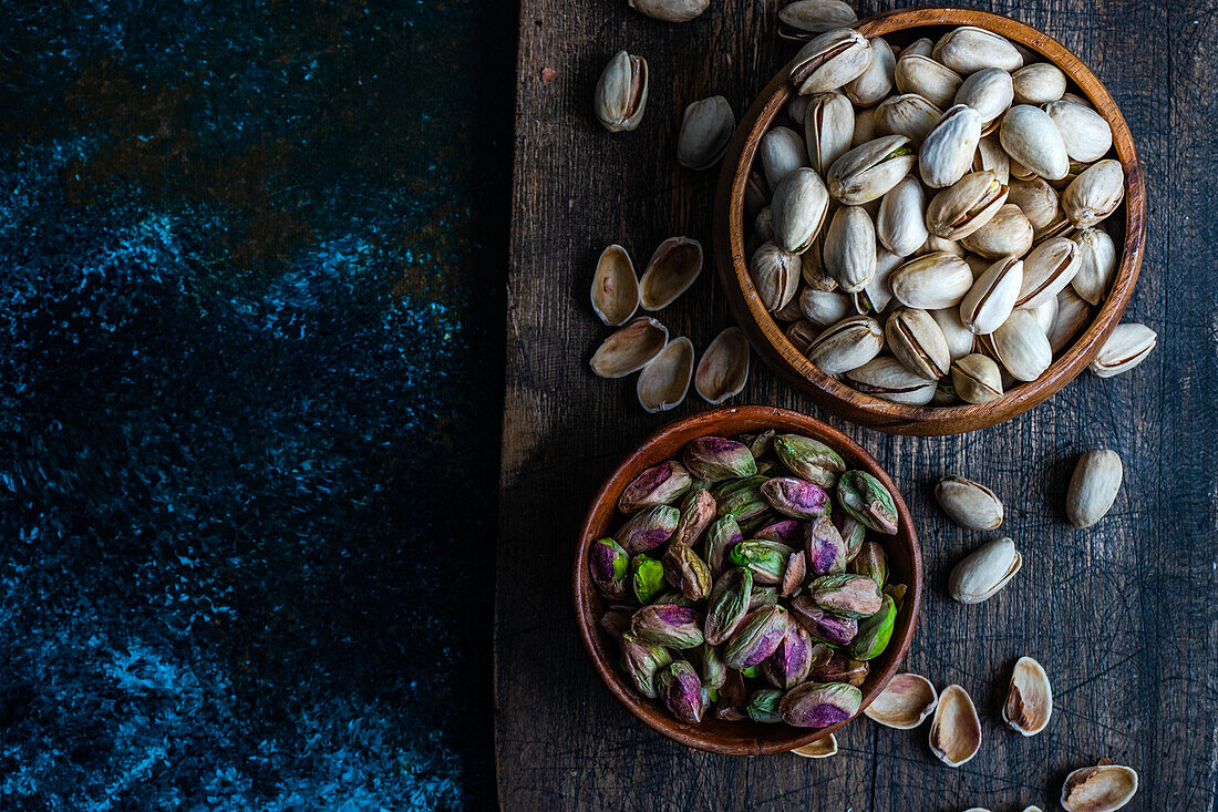 Raw organic pistachio nuts in the bowl on dark background