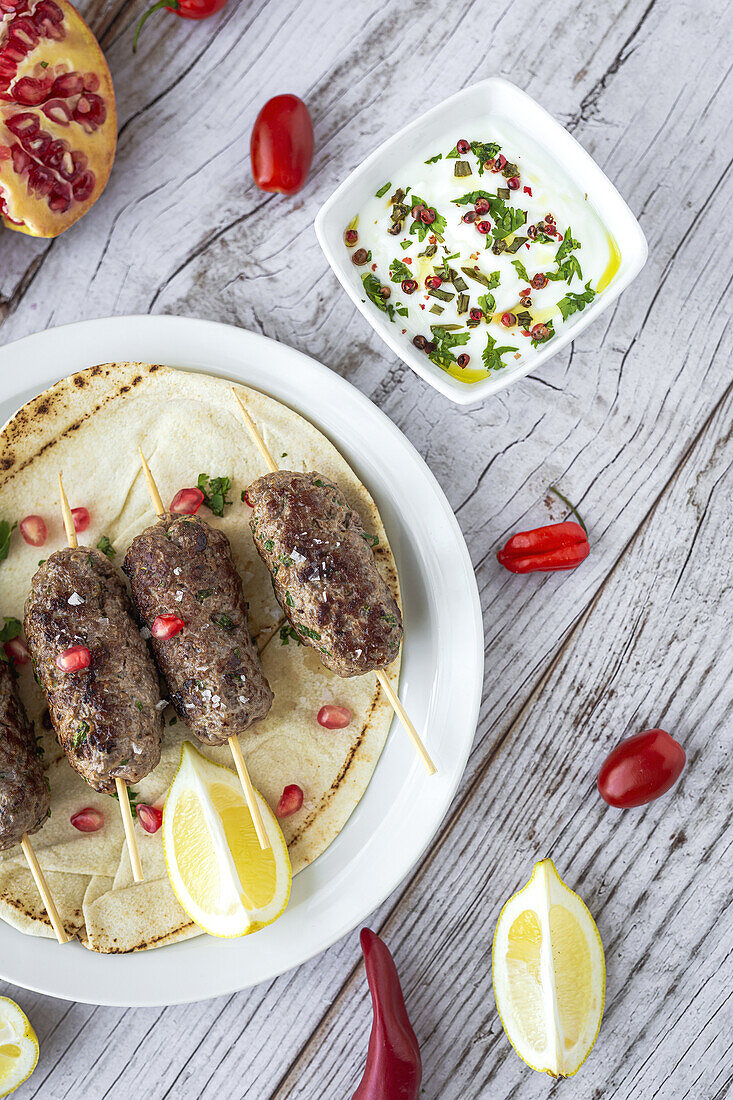 Traditional homemade kafta or kofta kebab beef and lamb with tomato sauce and yoghurt. Traditional Arabic and Turkish food. Halal food