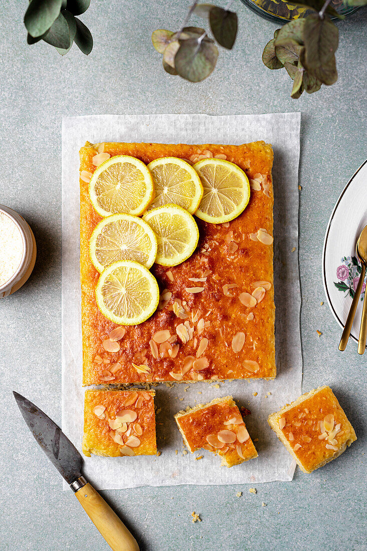 Square slice of tasty homemade lemon cake placed on grey background in kitchen