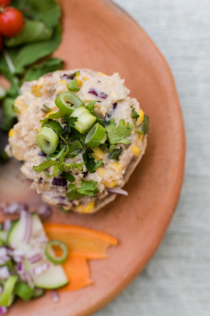 Draufsicht auf appetitliche Sandwiches mit Pilzpastete und Gemüse, serviert auf einem Holzteller auf einem Tisch für ein vegetarisches Mittagessen