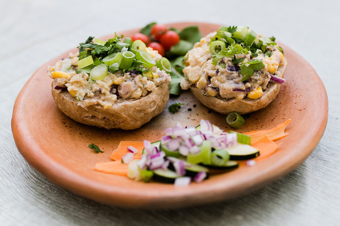 Appetitliche Sandwiches mit Pilzpastete und Gemüse, serviert auf einem Holzteller auf einem Tisch für ein vegetarisches Mittagessen