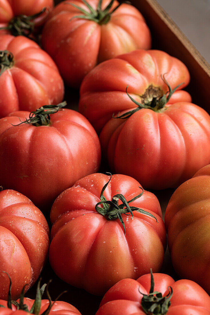 Von oben der Zweig der köstlichen frischen großen roten Tomaten auf Karton platziert