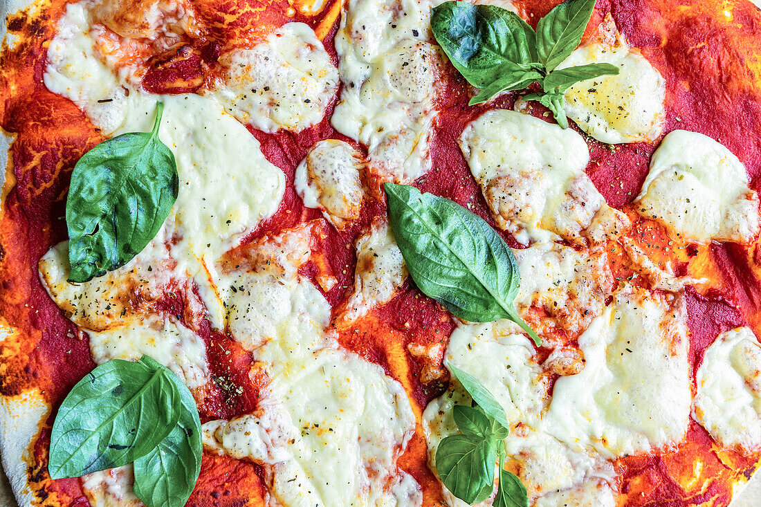 Von oben hausgemachte italienische Pizza Margherita mit frischen Basilikumblättern