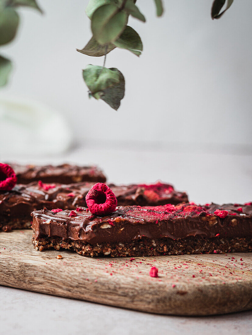 Close up of several chocolate bars with raspberry on a table