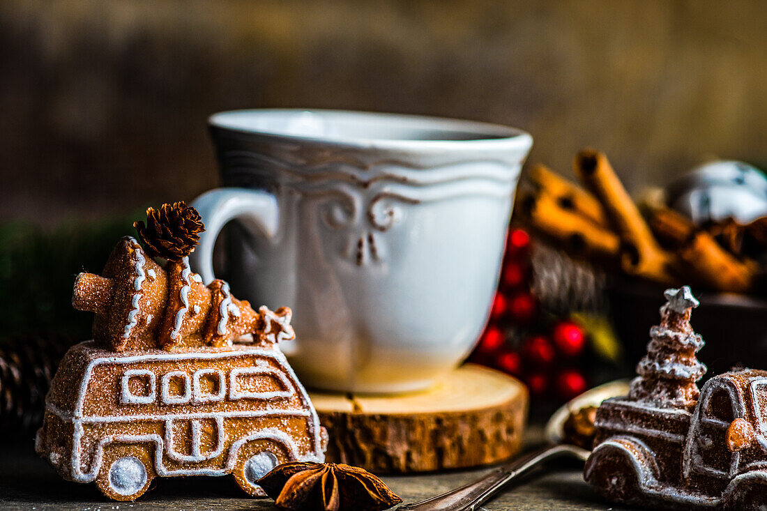 Becher mit Heißgetränk und Mini-Marshmallows mit Gewürzen auf weihnachtlich dekoriertem Hintergrund