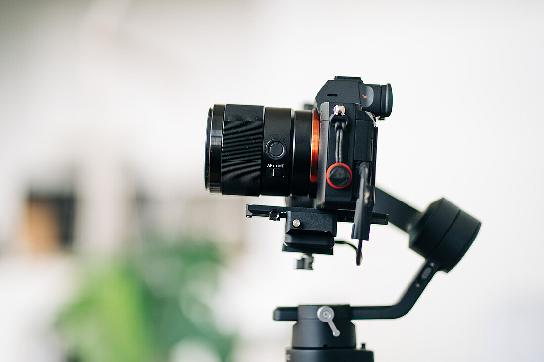 Zeitgenössische digitale Fotokamera mit Moduswahlrad und Sucher über dem Display auf unscharfem Hintergrund