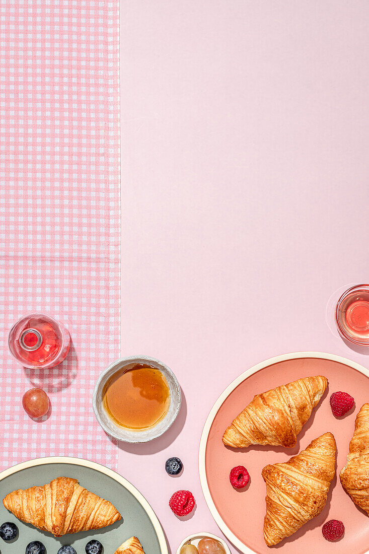 Von oben der Zusammensetzung der plated mit frisch gebackenen süßen Croissants serviert mit Beeren und Marmelade auf rosa Tisch platziert