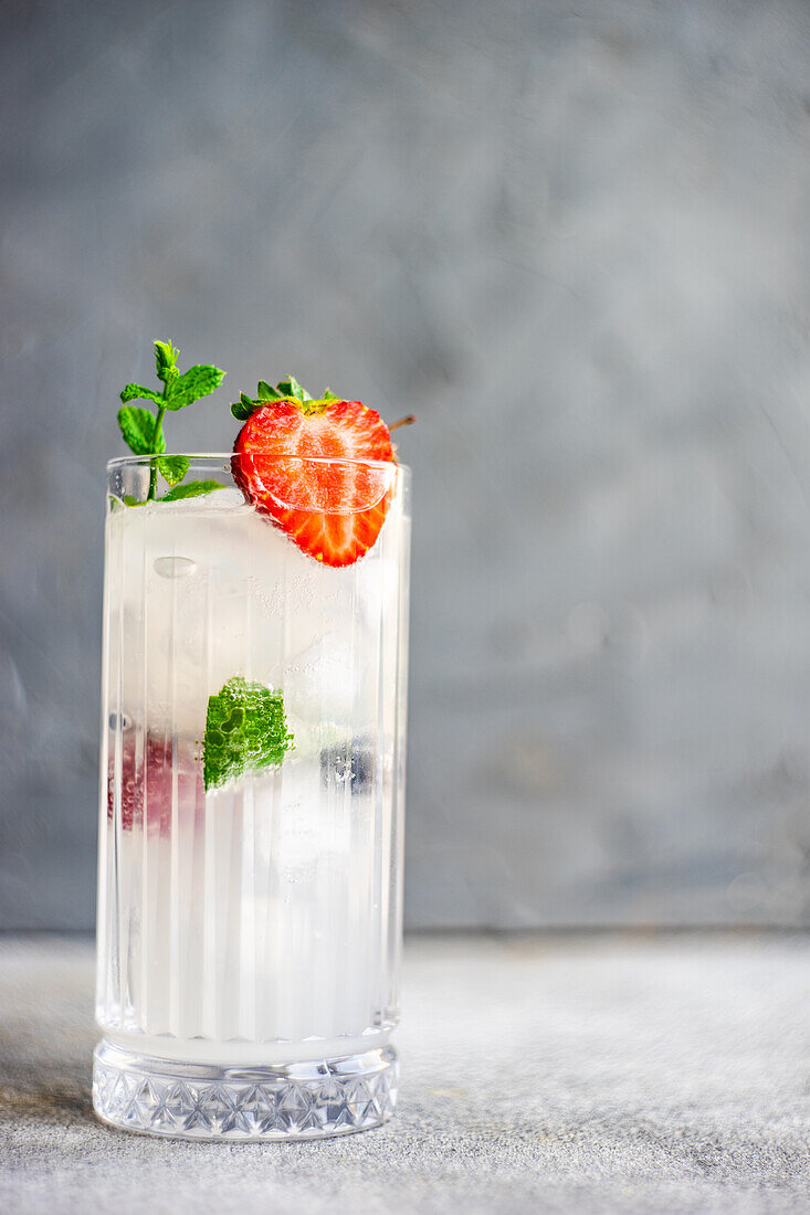Summer cocktail with ice and berries served in the crystal glass