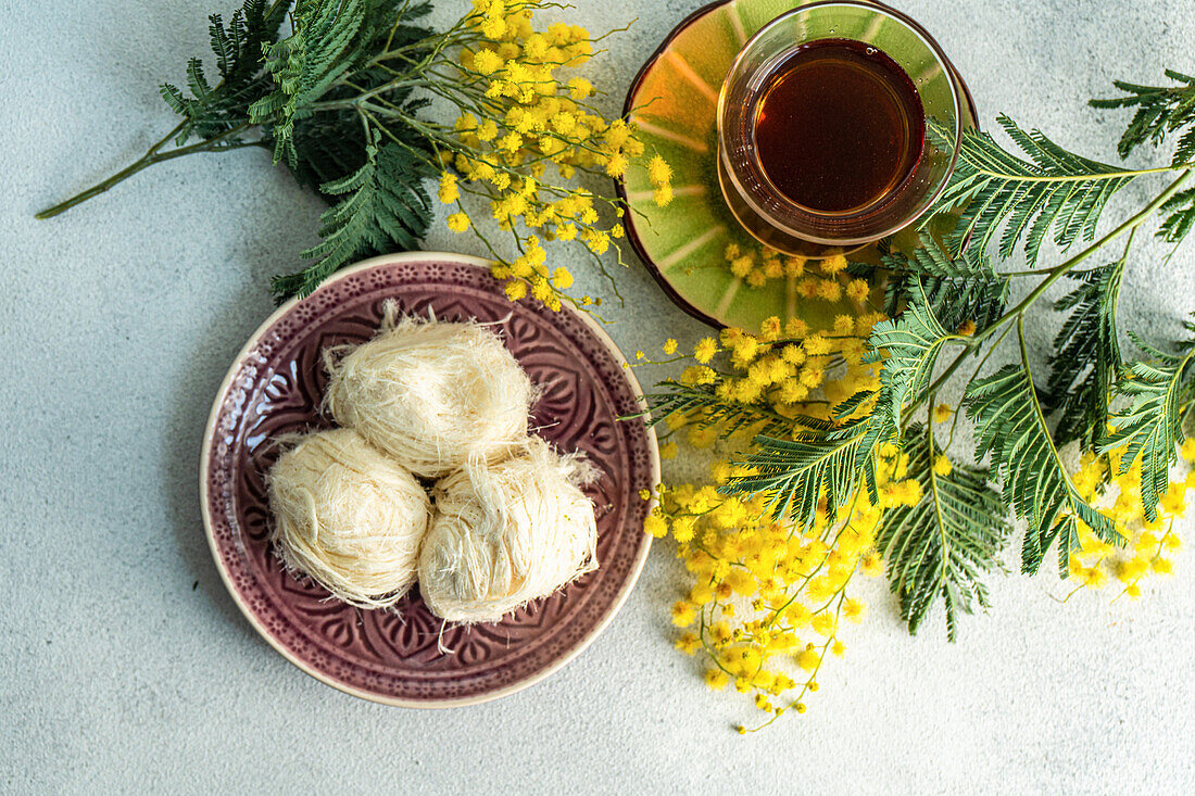 Turkish delight and tea on the table with yellow mimosa flowers