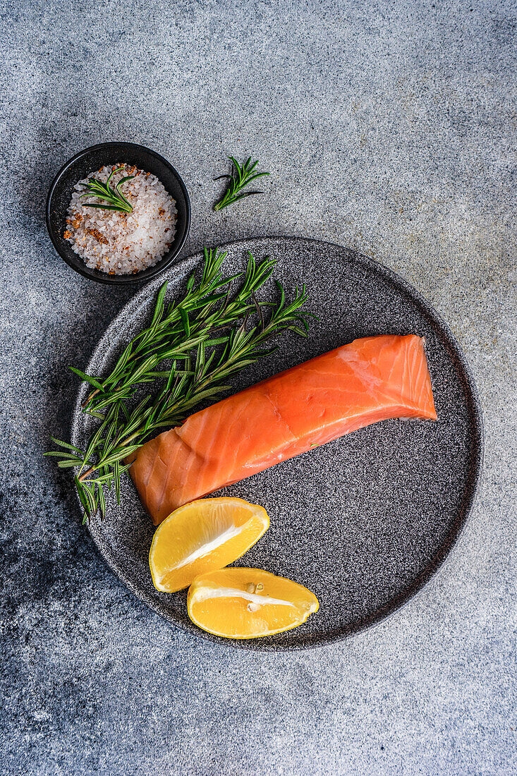 Healthy plate with salmon fish , lemons and rosemary herbs