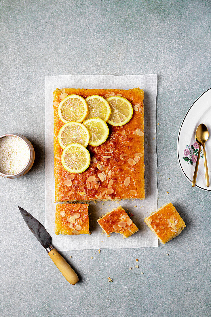 Square slice of tasty homemade lemon cake placed on grey background in kitchen