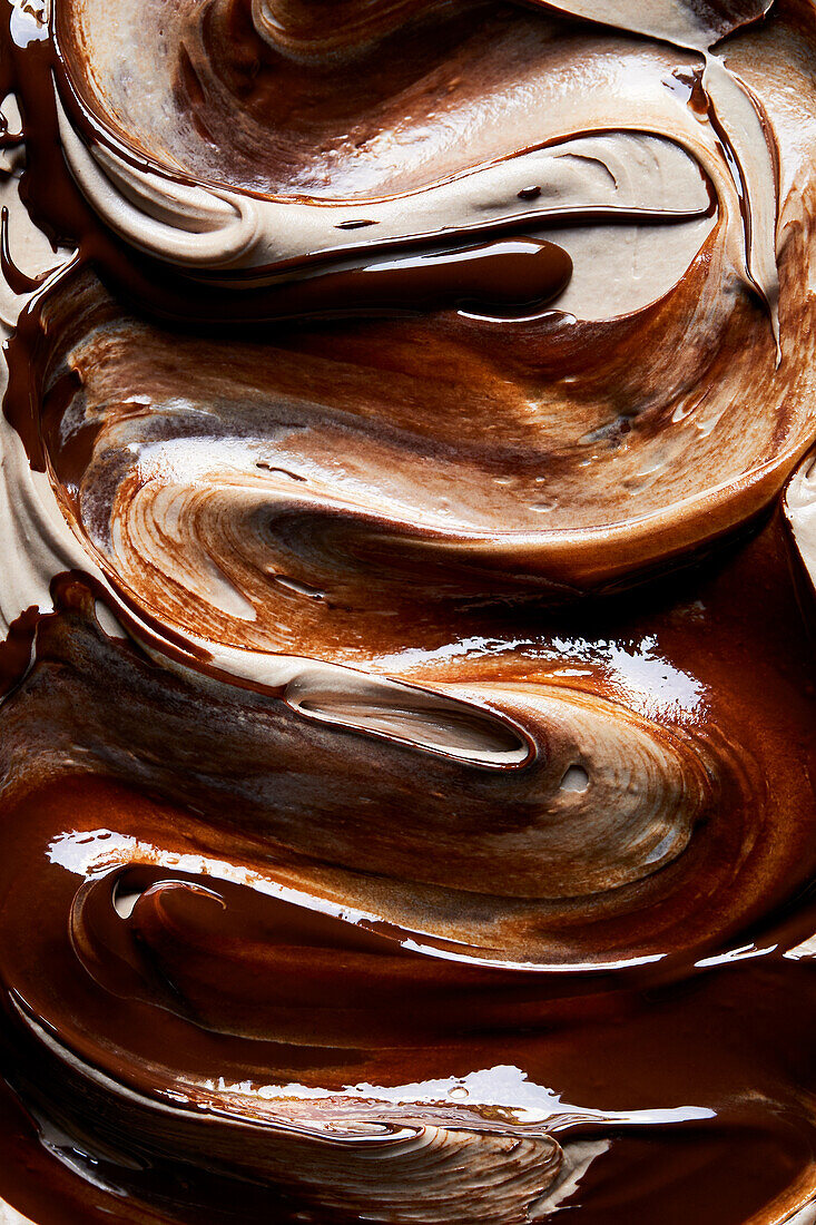 Full frame closeup background of delicious sweet melted chocolate glaze texture on top of cake