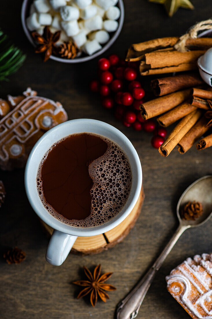 Von oben Becher mit heißer Schokolade und Mini-Marshmallows mit Gewürzen auf Hintergrund mit Weihnachtsdekorationen