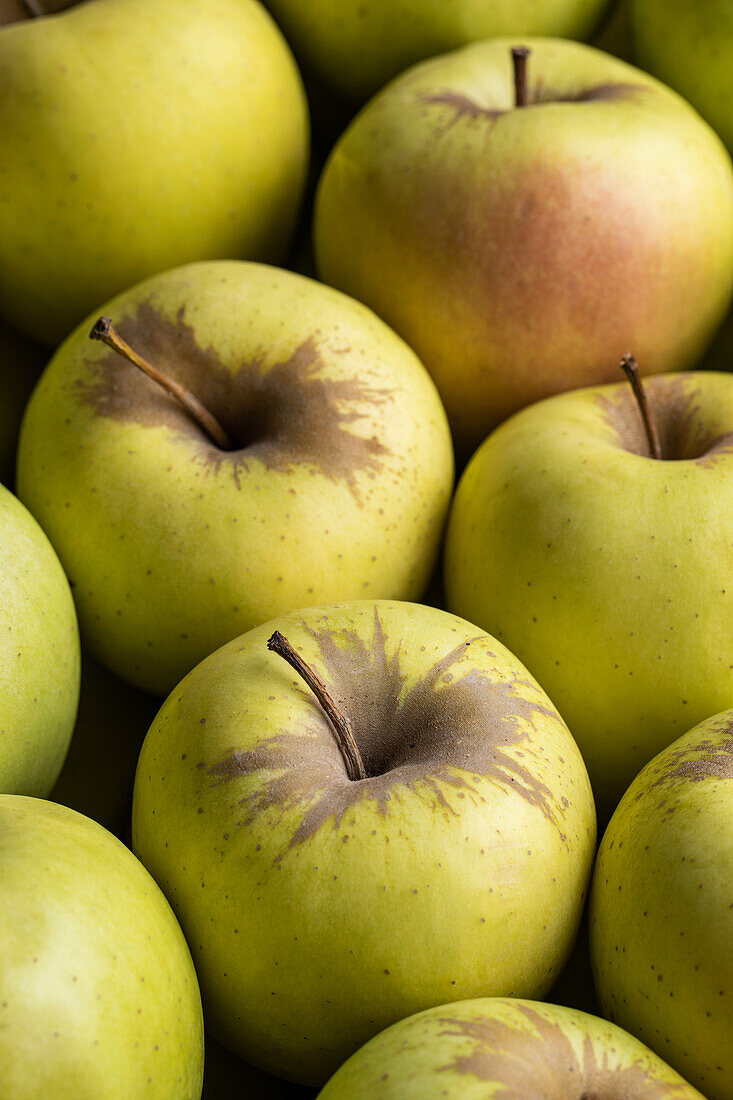 Vollbildhintergrund mit köstlichen frischen gelben Äpfeln, die in Reihen angeordnet sind