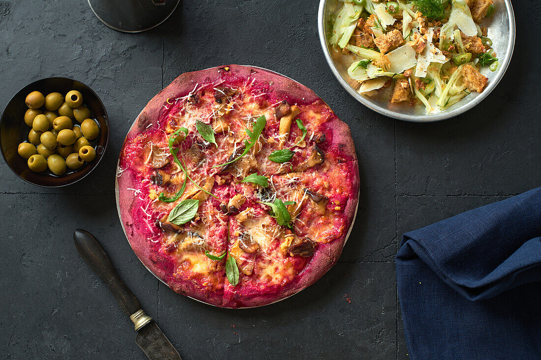 Purple colored rustic pizza with beetroot and vegetarian topping. Top view healthy food recipe