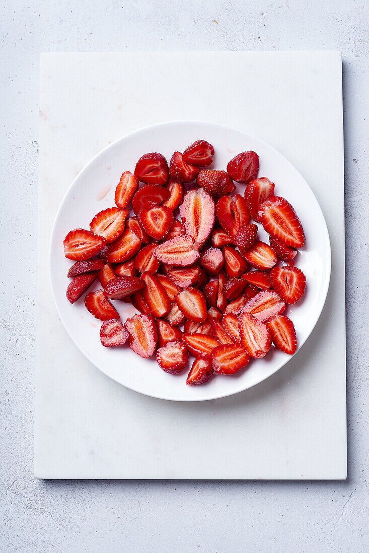 Sugar-coated sliced strawberries on a plate. Cooking dessert or jam