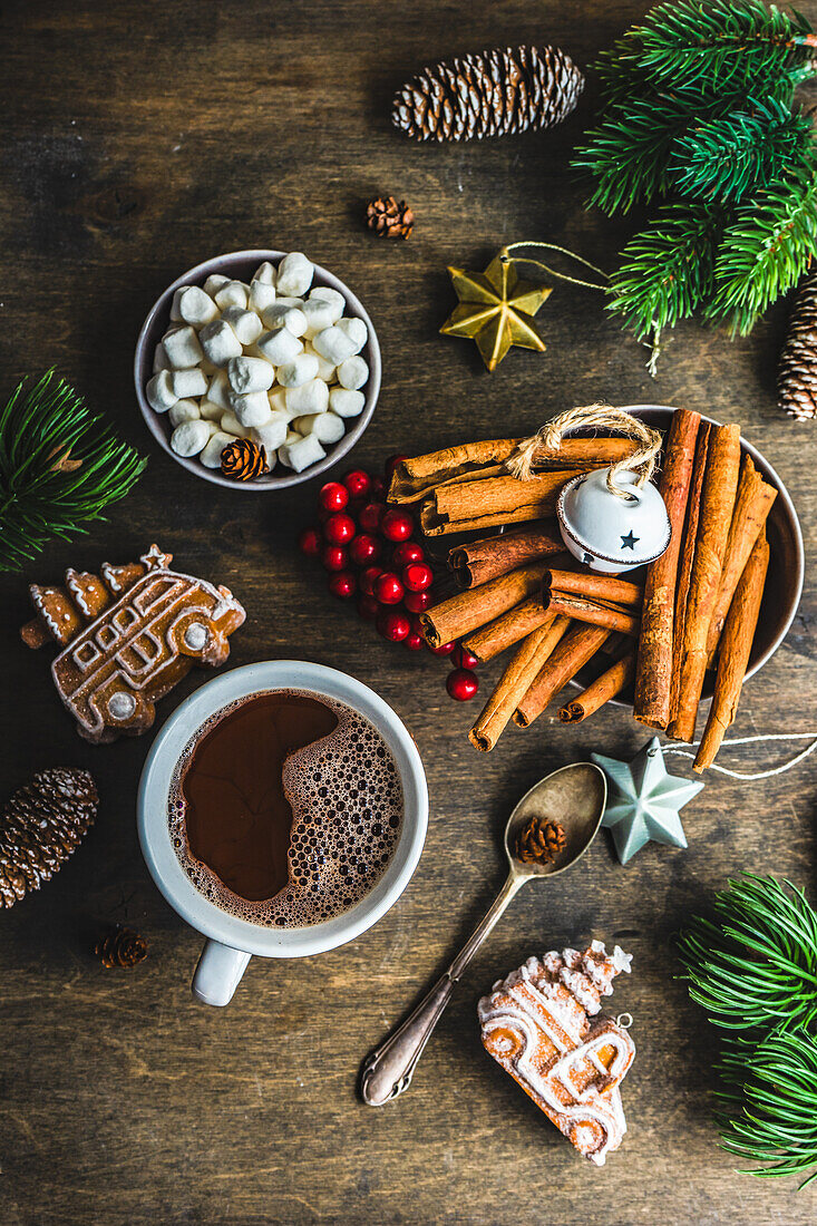 Von oben Becher mit heißer Schokolade und Mini-Marshmallows mit Gewürzen auf Hintergrund mit Weihnachtsdekorationen