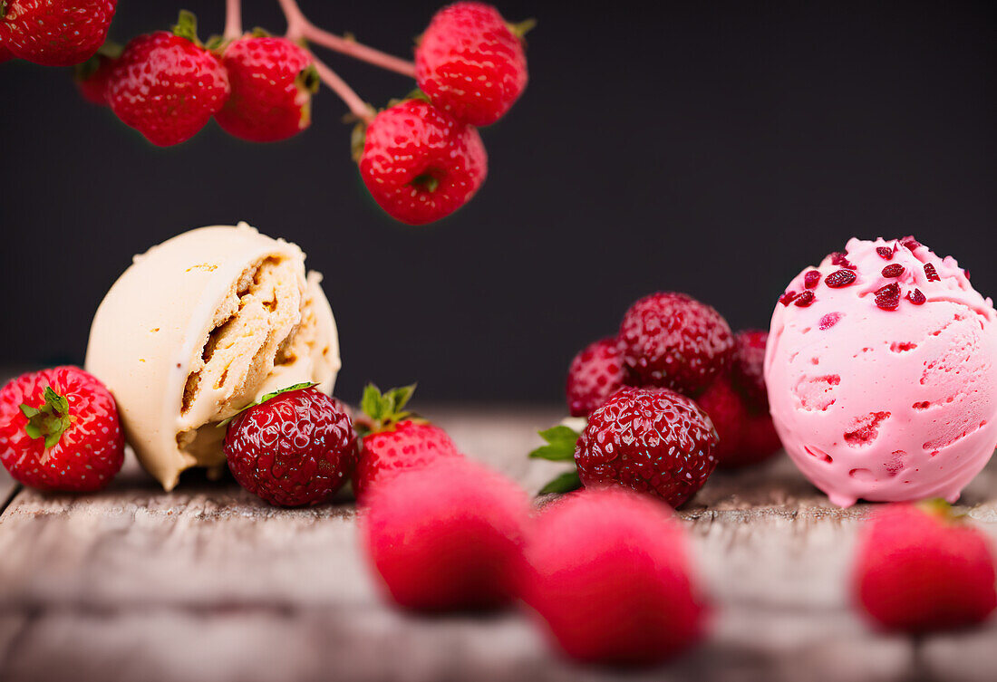 Yummy Vanille und Erdbeere Eis Kugeln auf dem Tisch mit roten reifen Beeren platziert