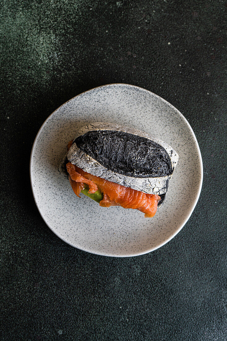 Gesunder Snack mit Sauerteig und Aktivkohlebrötchen und Lachsfisch im Sandwich