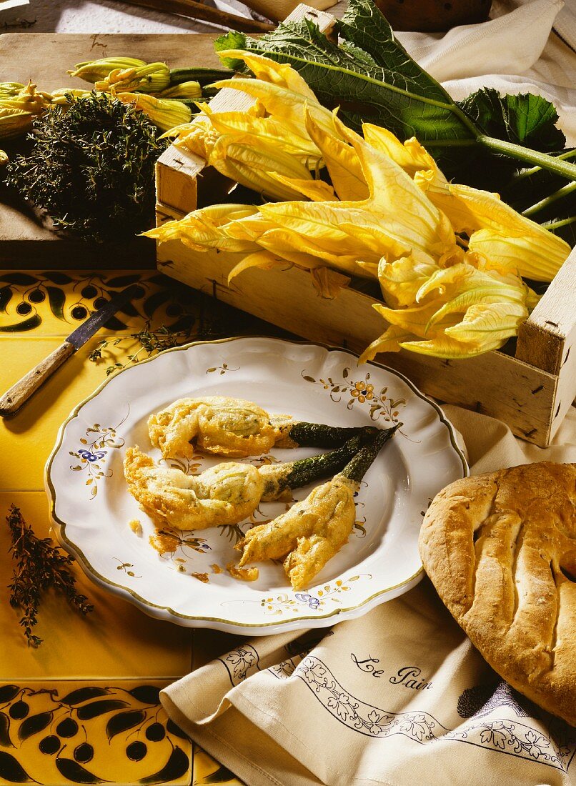 Stuffed, fried courgette flowers, decor: fresh flowers, bread