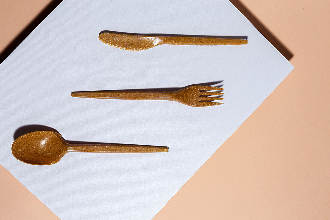 Overhead view of brown eco friendly cutlery on pastel background