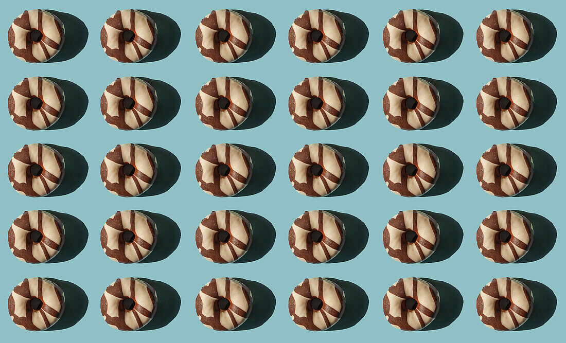 Top view of many donuts covered with chocolate black and white on blue background