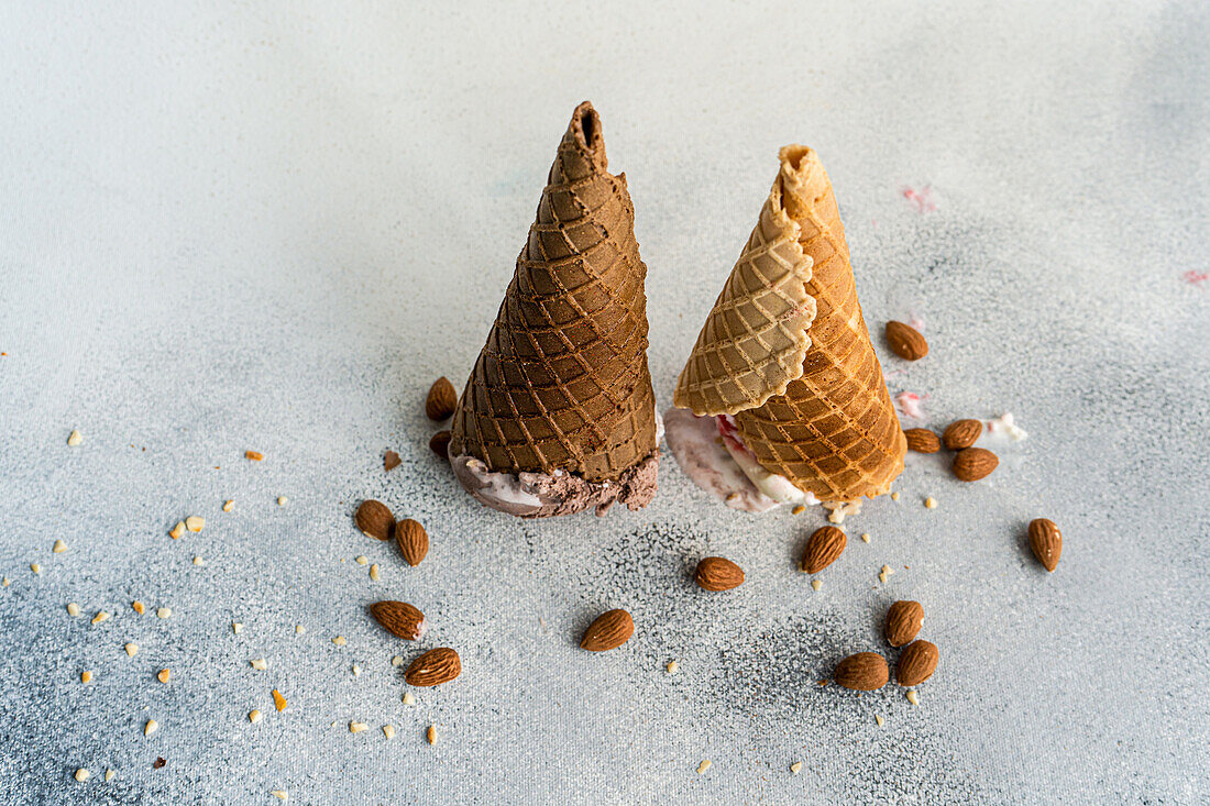 Upside down waffle cones with ice cream on concrete background
