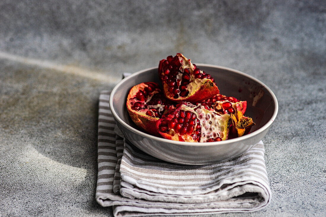 Ripe organic pomegranate fruit on the ceramic plate and tea towel
