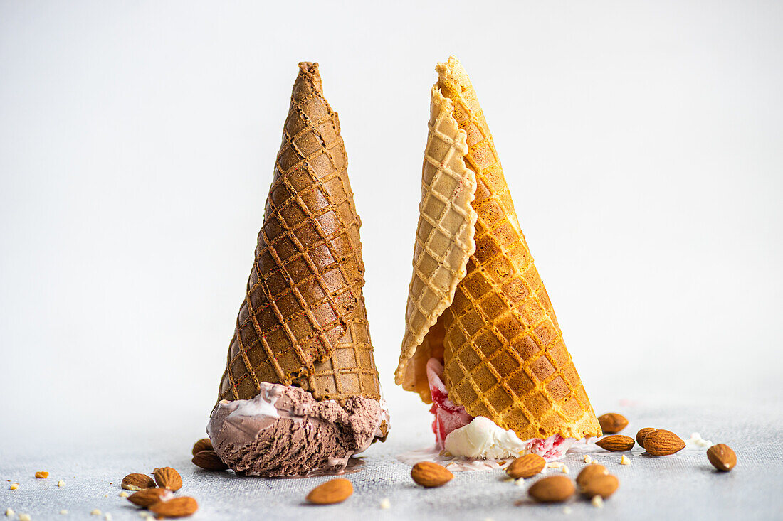Upside down waffle cones with ice cream on concrete background