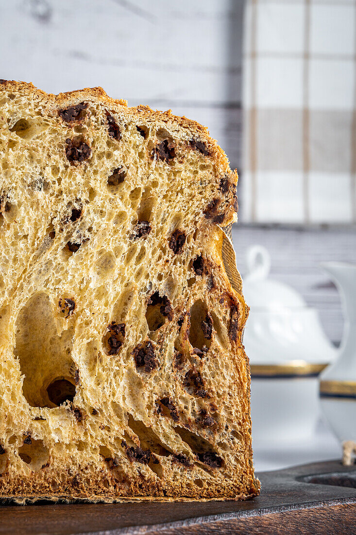 Nahaufnahme einer leckeren Hälfte eines hausgemachten Panettone auf einem Holztisch vor einem hellen Hintergrund