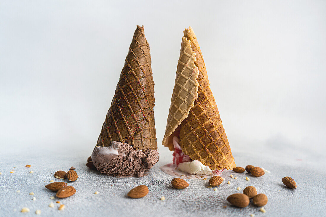 Umgedrehte Waffeltüten mit Eiscreme auf Betonhintergrund