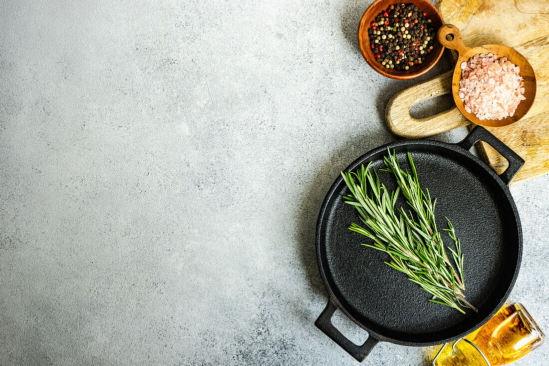 Top view of cooking concept with spices and rosemary herb on concrete background