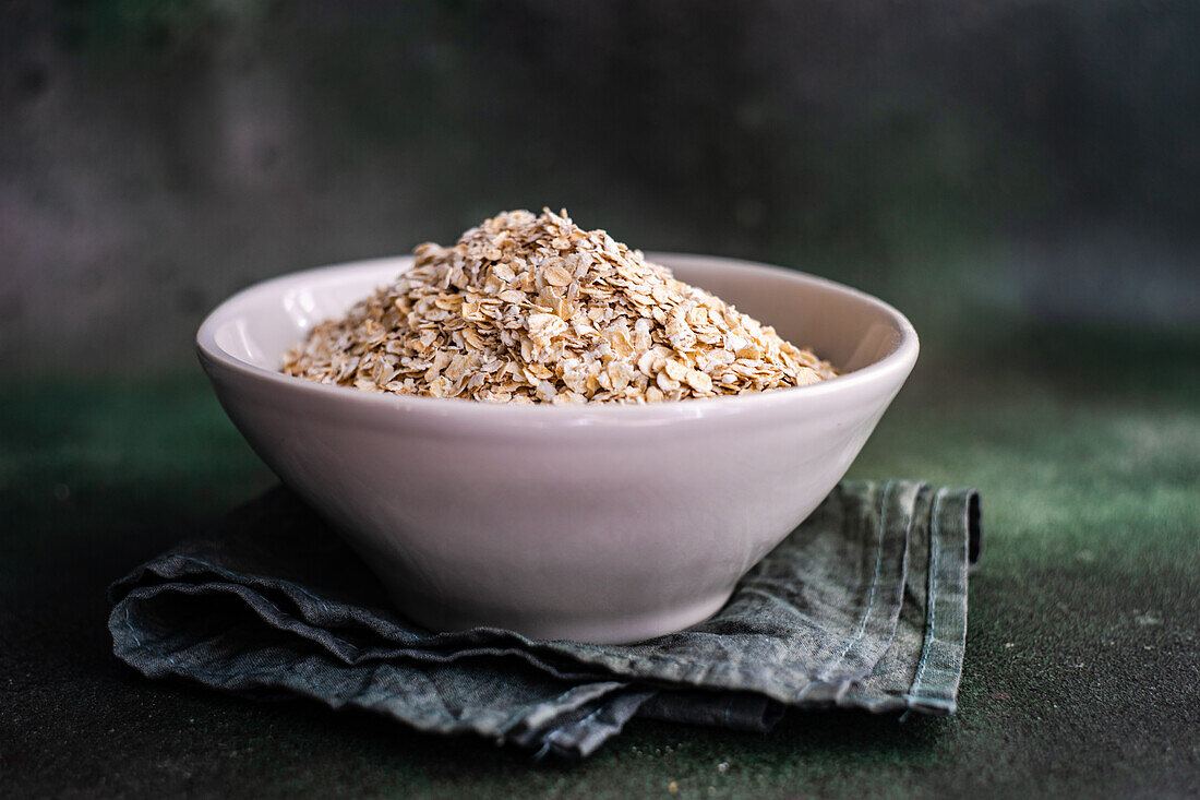 Gesunde rohe Haferflocken in der Schüssel als Porridge-Kochkonzept