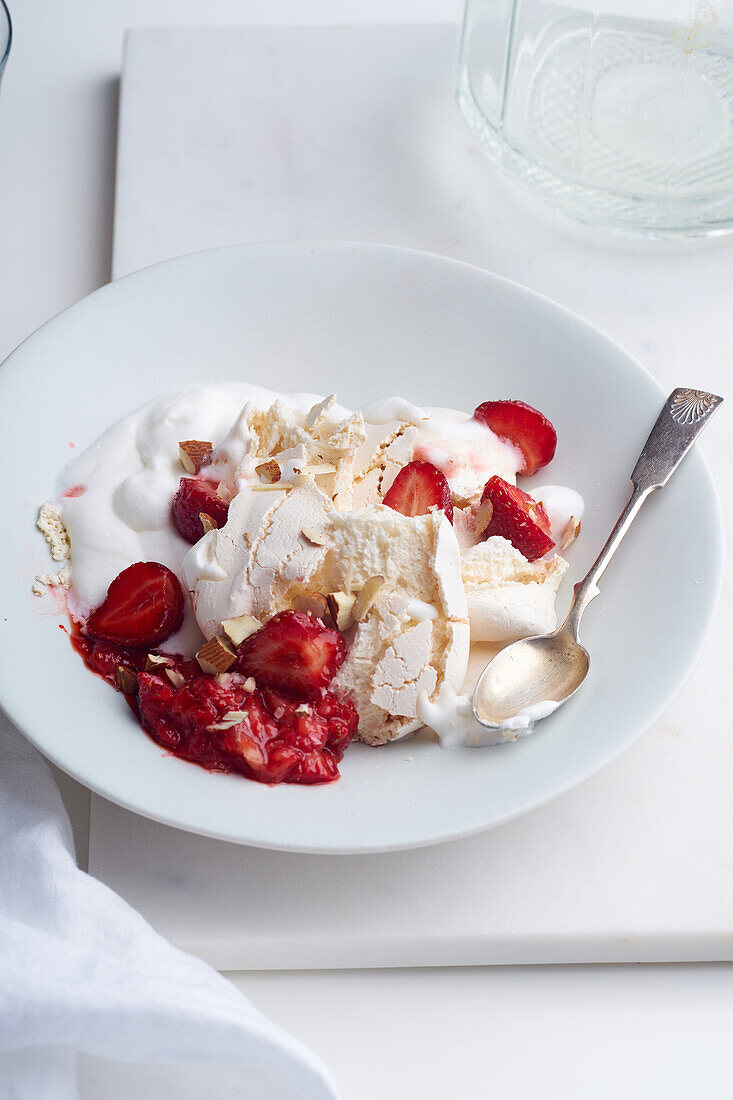 Dessert mit Beeren, Baiser und Schlagsahne. Eton's Mess mit Erdbeeren, süße Leckerei mit Sommerstimmung