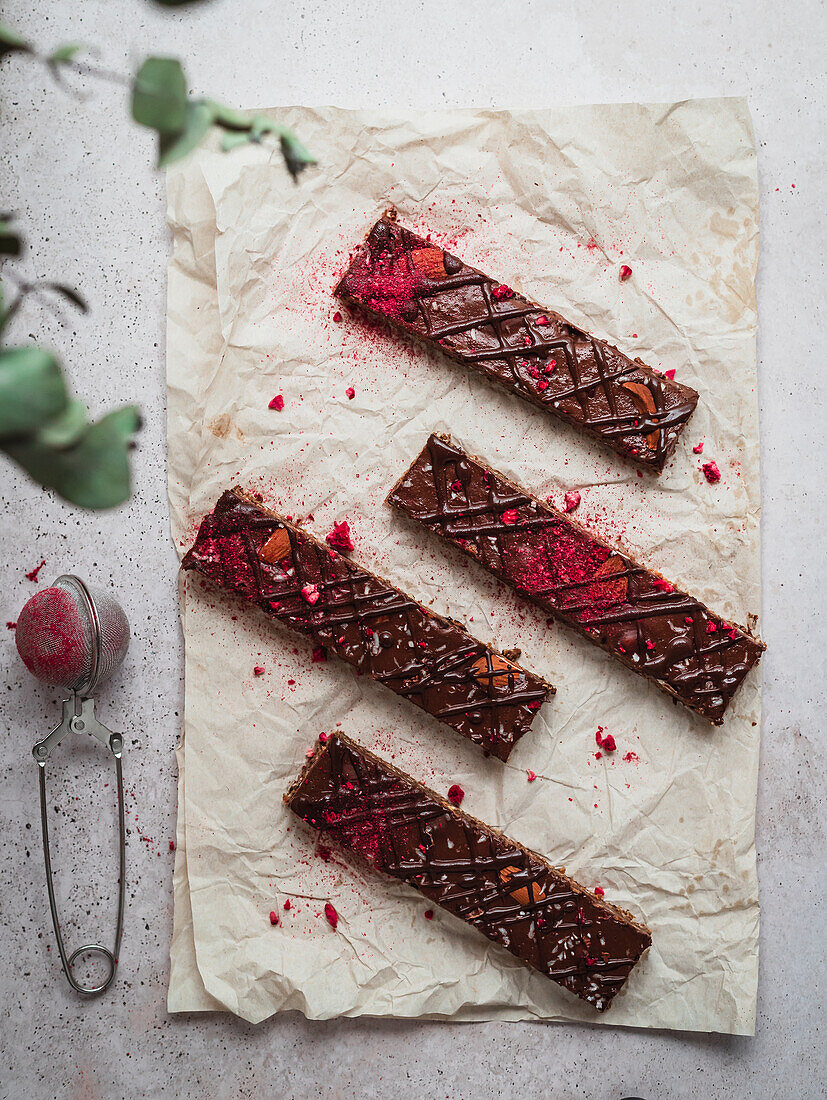 Close up of several chocolate bars with raspberry on a table