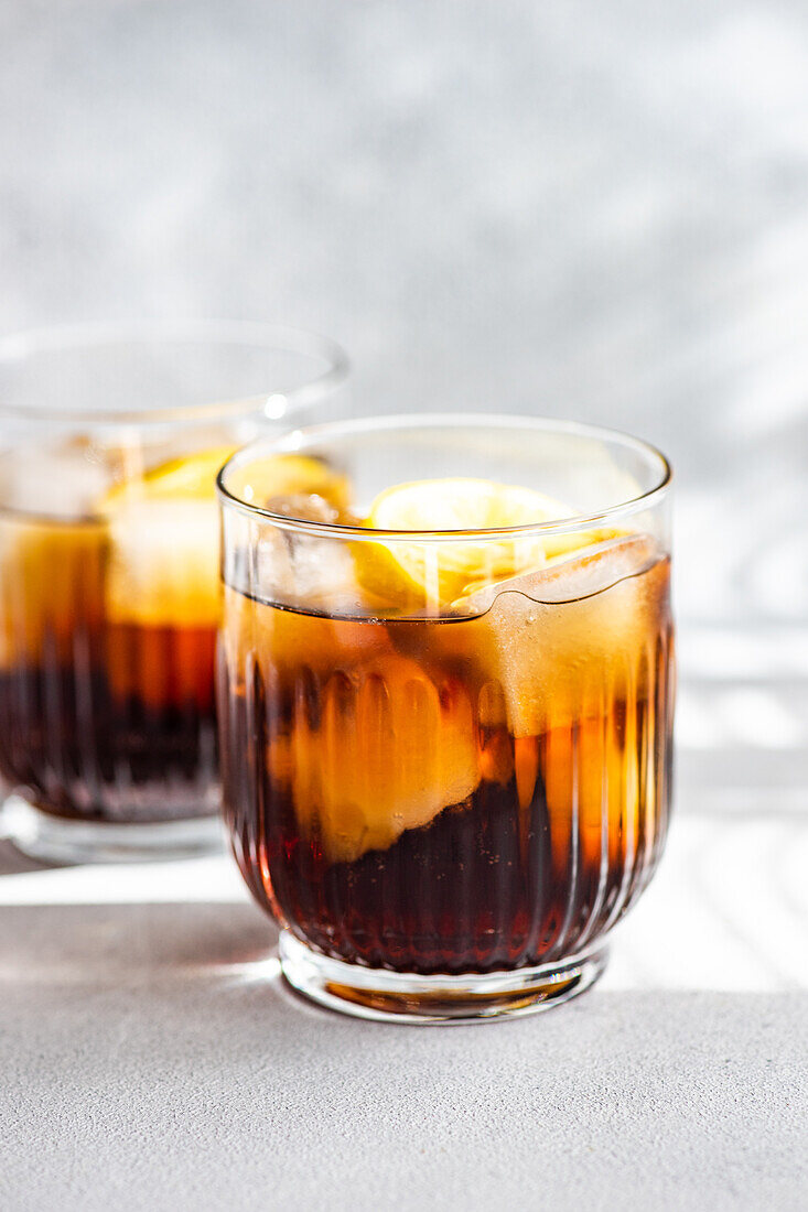 Alkoholcocktail Cuba Libre mit Orangenscheibe und Eis im Glas