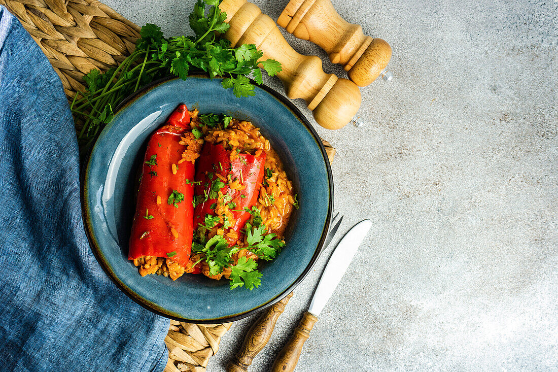 From above stuffed bell peppers stewed in blue vintage bowl with tomato sauce