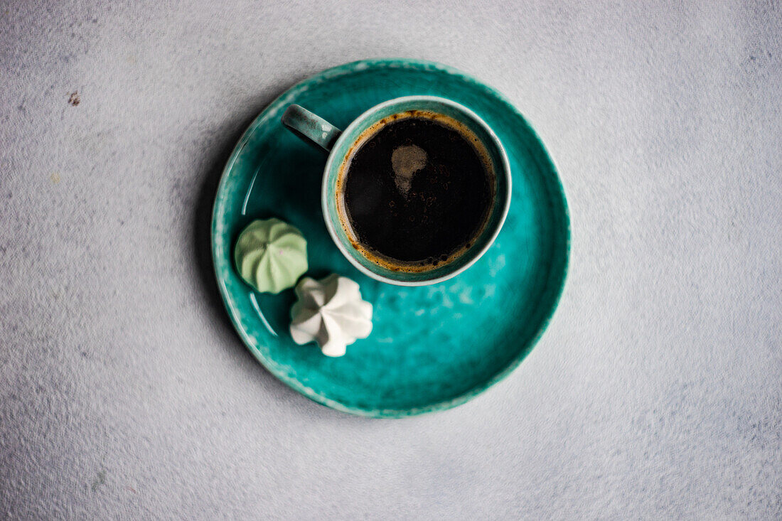 von oben Tasse Kaffee mit Mini-Bonbons auf Betontisch