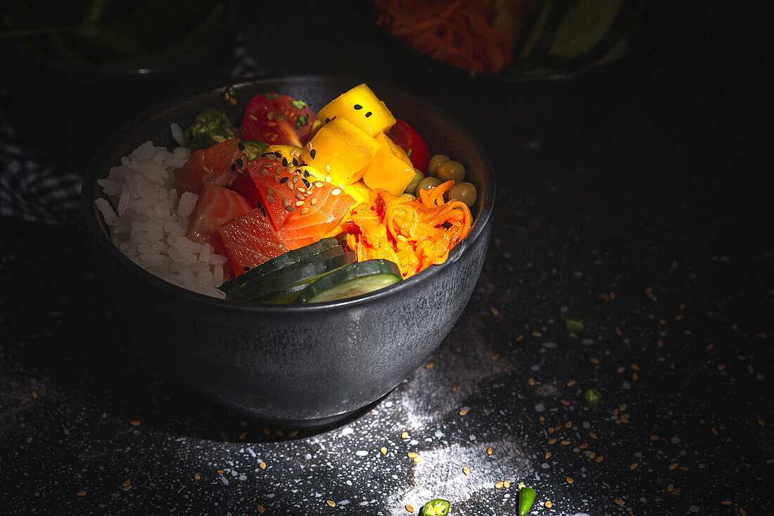Asiatischer Poke mit Lachs und Reis mit verschiedenen Gemüsesorten, serviert in einer Schüssel auf einem Tisch in einem Restaurant