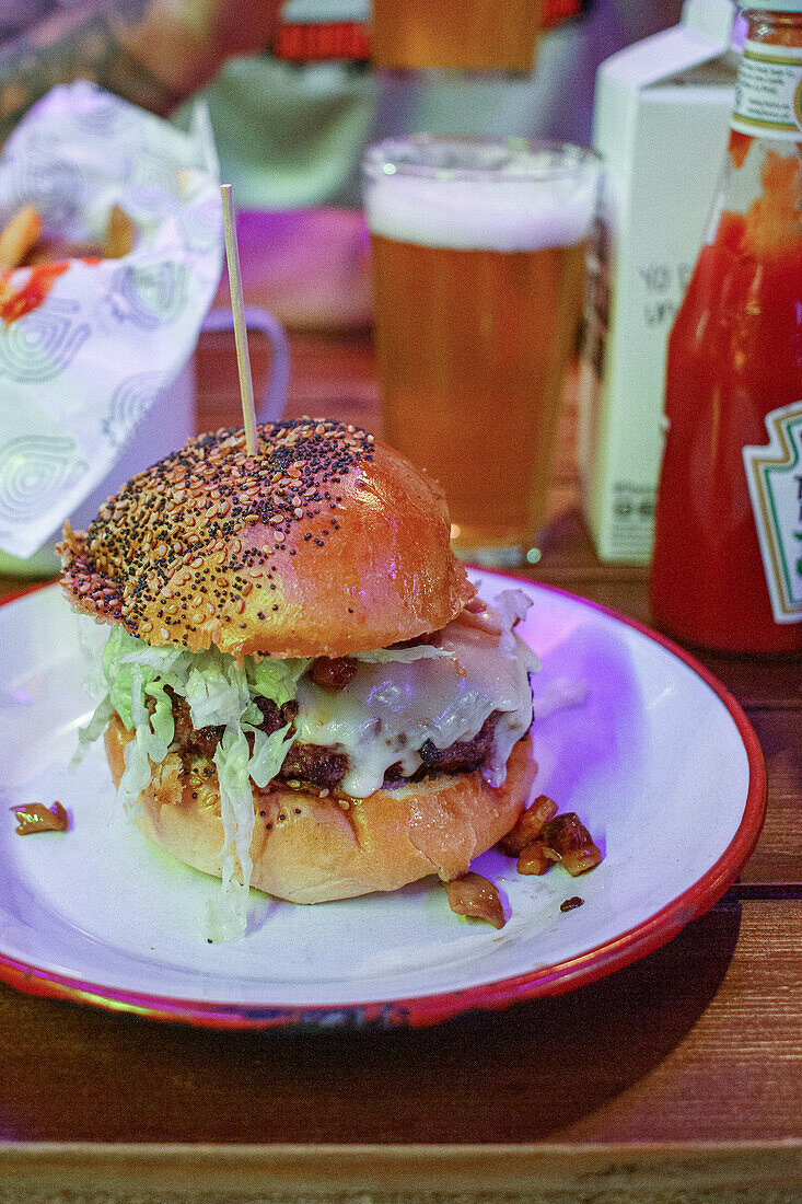 Delicious burger with meat, lettuce and cheese served on plate in restaurant