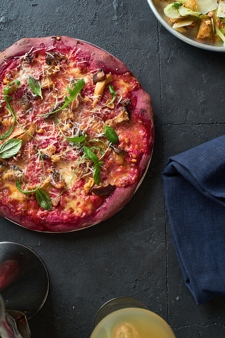 Lila gefärbte rustikale Pizza mit Roter Bete und vegetarischem Belag. Ansicht von oben gesundes Essen Rezept