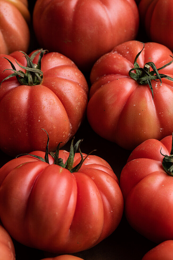 From above of branch of delicious fresh big red tomatoes placed on cardboard box