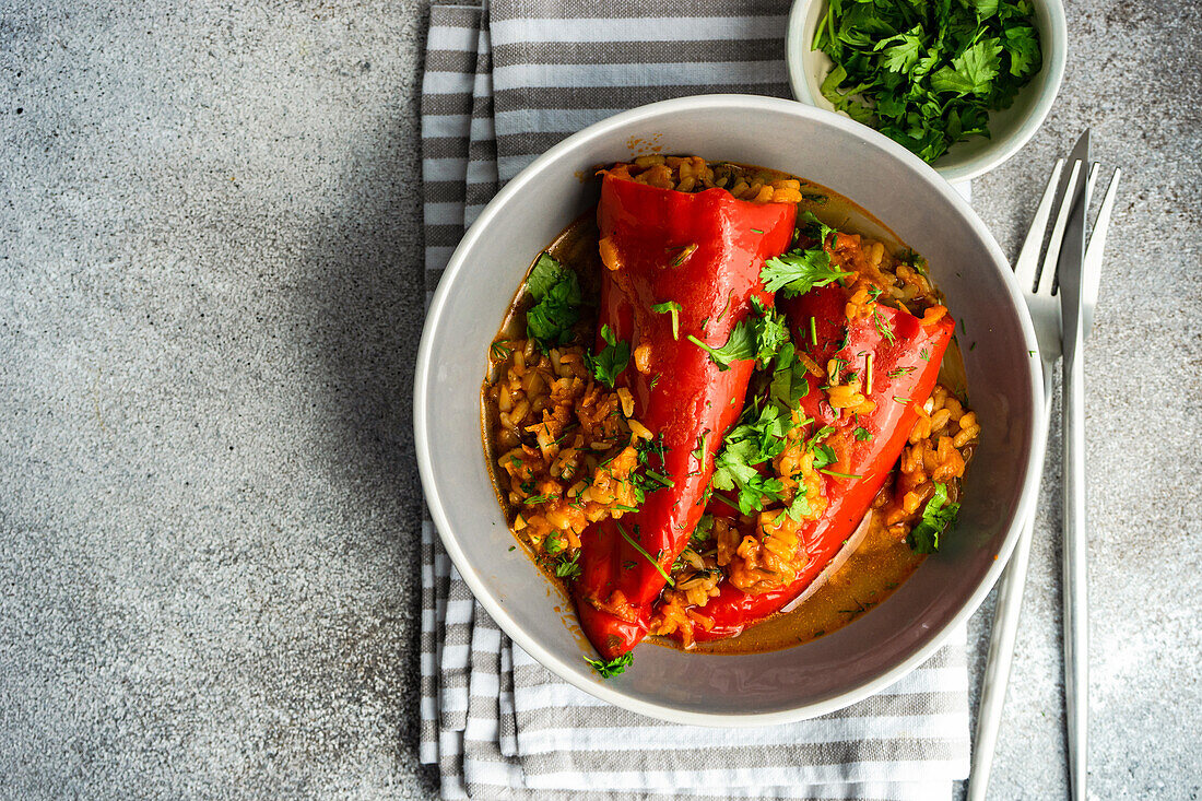 From above stuffed bell peppers stewed in stone pan with tomato sauce