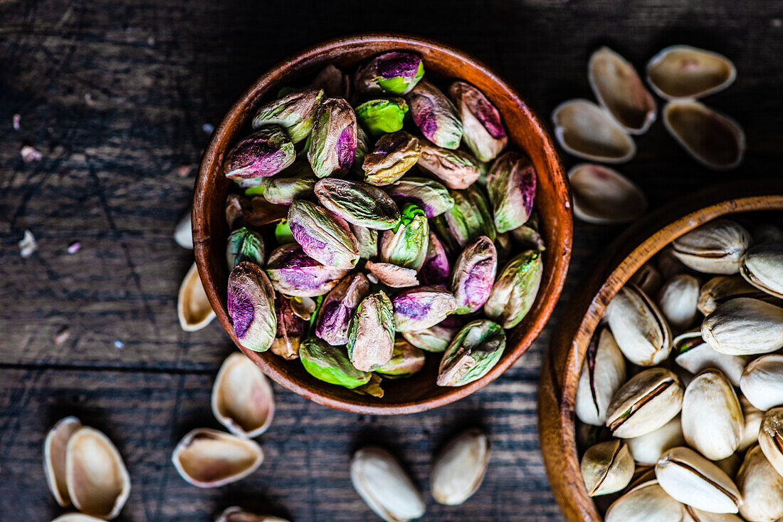 Raw organic pistachio nuts in the bowl on dark background